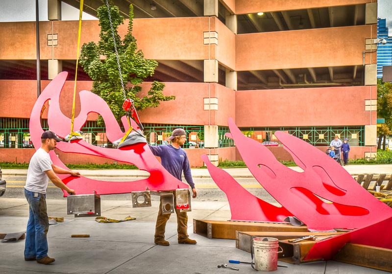 Workers guide one of the Phoenix's wings into position.