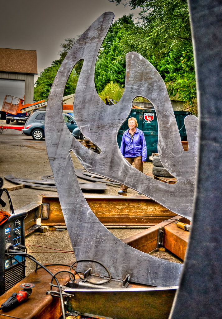 Cynthia peers through a hole in one of the Phoenix's wings while construction continues around her