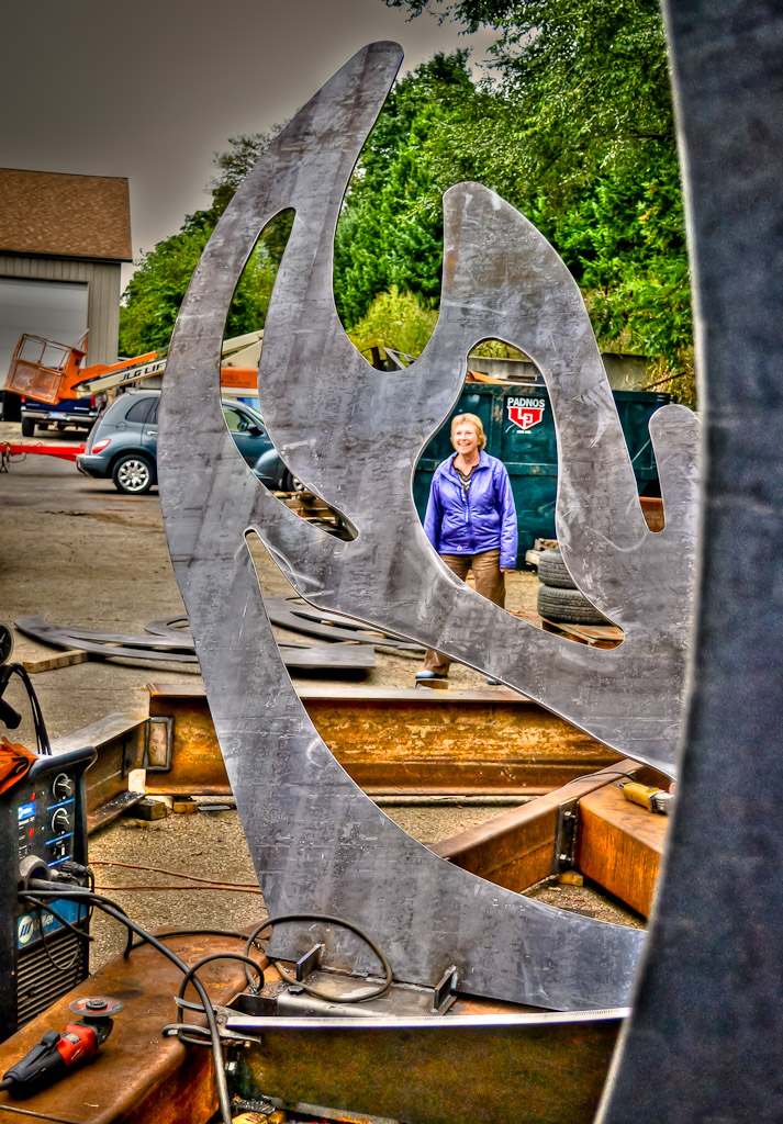 Cynthia peers through a hole in one of the Phoenix's wings while construction continues around her